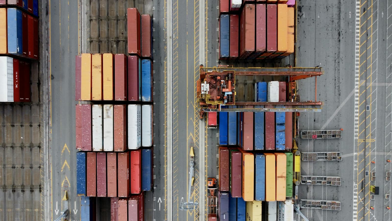 Rows of stacked containers and a yard crane seen from directly above.